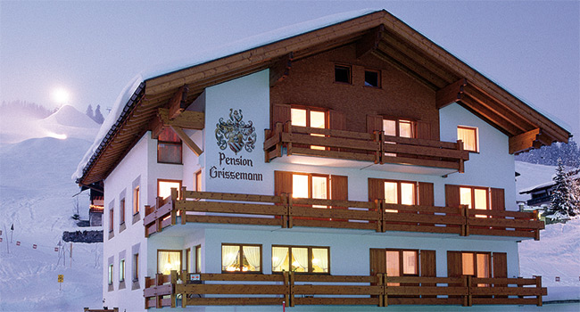 Ansicht der Pension Grissemann in Lech am Arlberg, hinter dem Haus die Skipiste Schlegelkopf